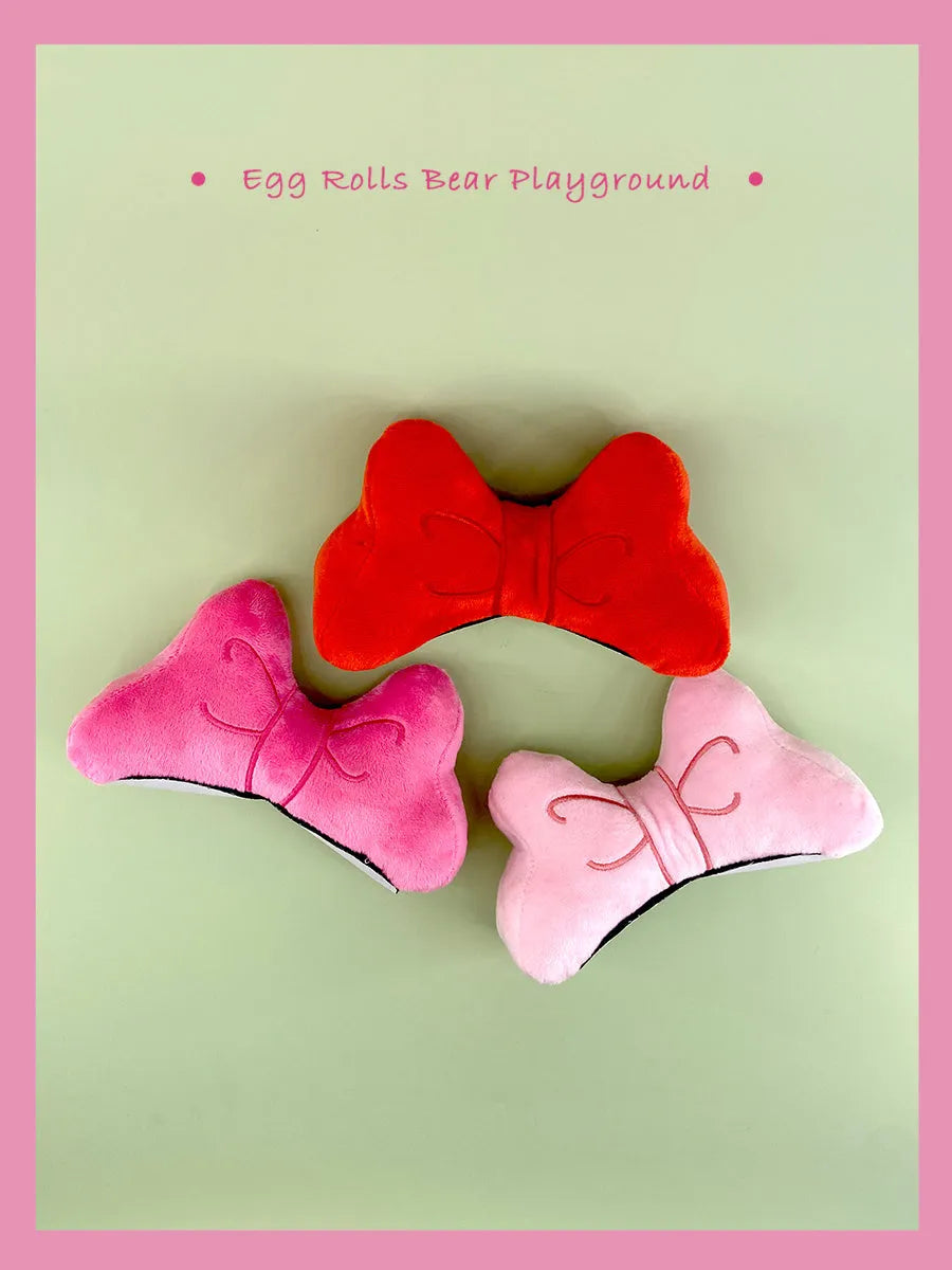 Soft plush decorative bow for motorcycle and ski helmets in red or pink.