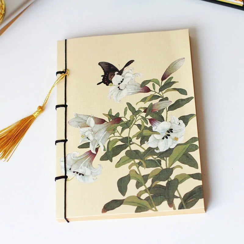 A5 antique wire-bound notebook with glossy embossed cover featuring a retro painting design, shown open.