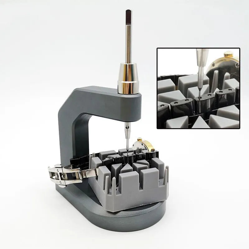 Silver-toned tool steel press strap removal tool for watches and jewellery on a plain background.
