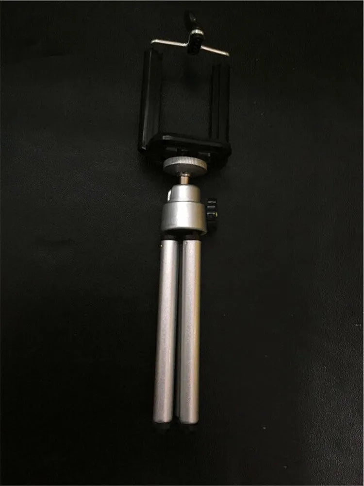 Black desktop phone holder with a two-section adjustable bracket arm holding a mobile phone.