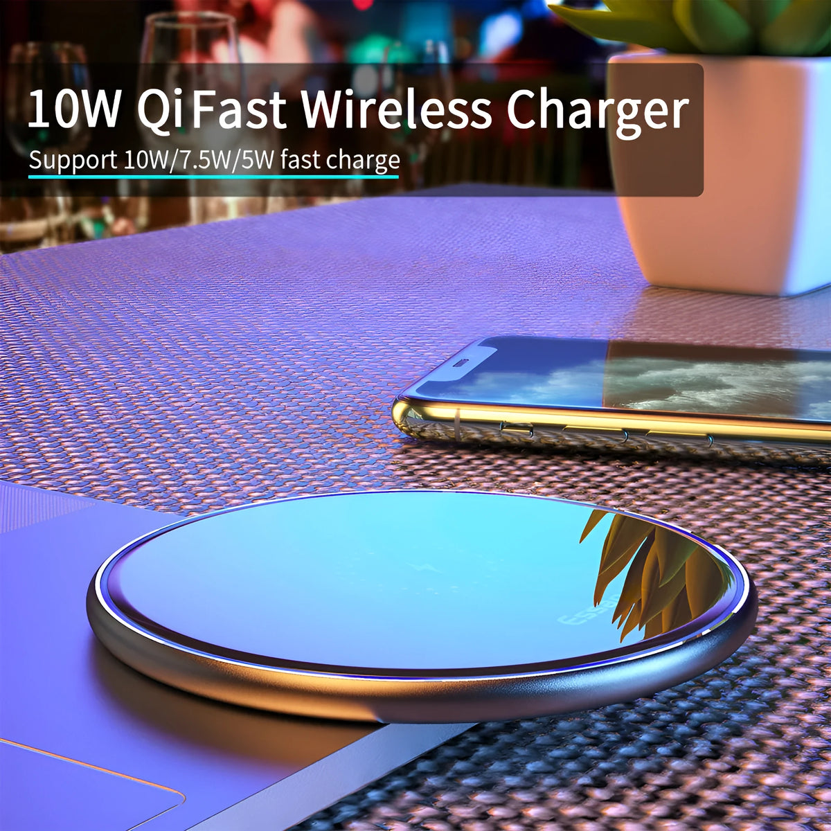 Black Qi fast wireless charging pad on a desk next to a smartphone, showing a blue LED charging indicator light.