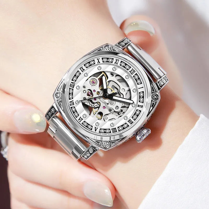 Leather strap mechanical wristwatch with luminous hands on a black dial.
