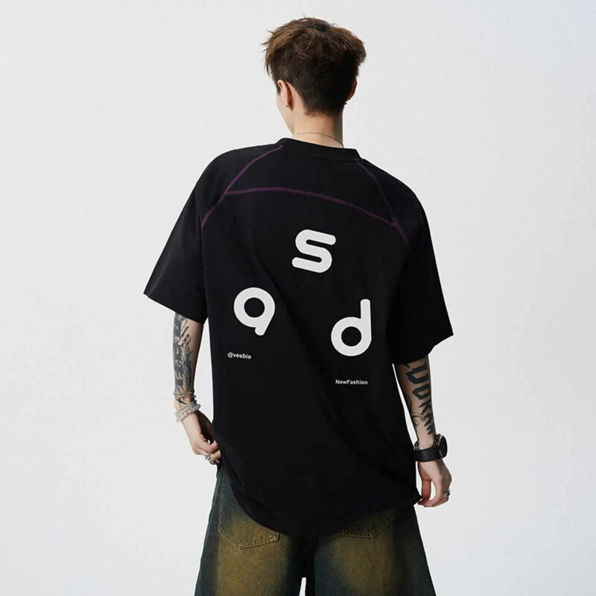 Loose-fitting black cotton T-shirt with a letter print on the chest, showing short sleeves and a round neck.