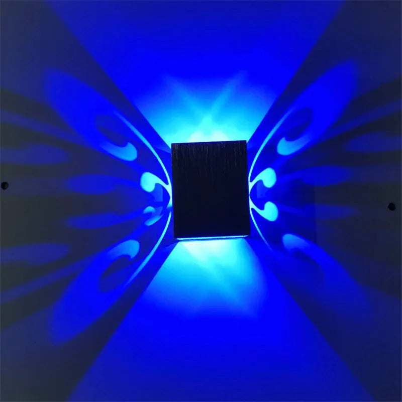 Modern aluminium butterfly-shaped LED wall lamp with remote control on a plain background.