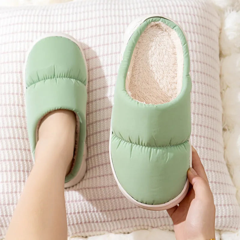 Blue down cotton slippers with artificial leather upper, thick rubber sole, and plush lining shown on a wooden floor.