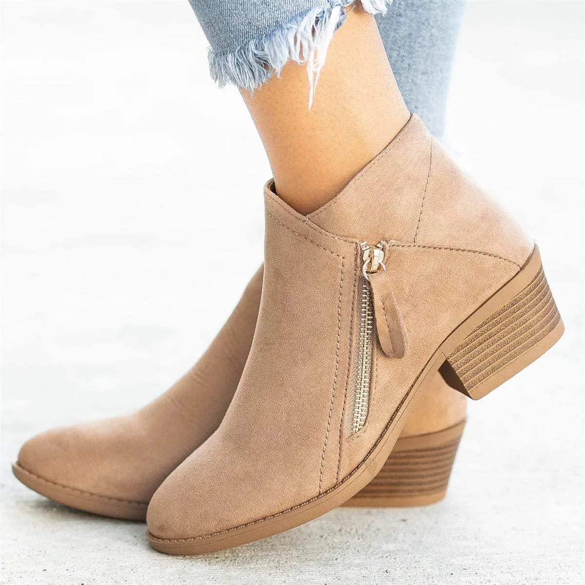 Women's beige suede ankle boots with a side zip and a chunky block heel.