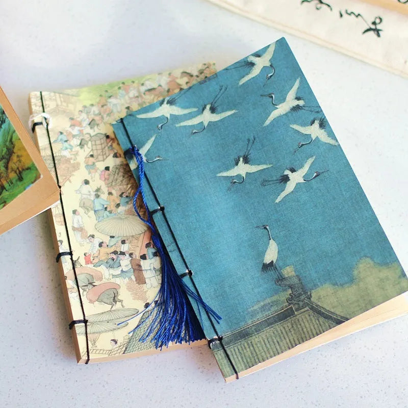 A5 antique wire-bound notebook with glossy embossed cover featuring a retro painting design, shown open.