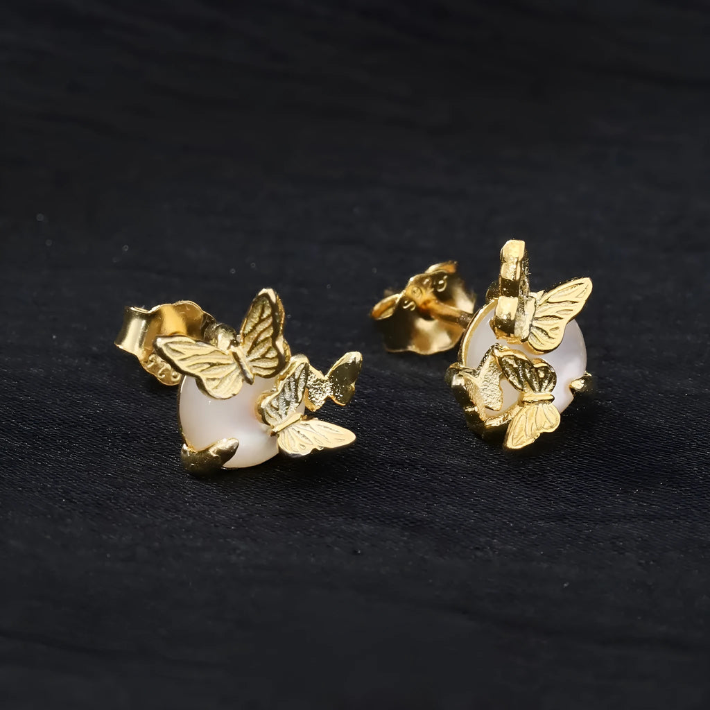 Close-up of 925 silver butterfly stud earrings with animal detail in gold tone finish.