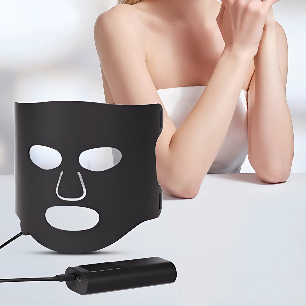 Black and white LED phototherapy face mask with controller showing seven different coloured light modes for skincare.