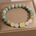 Women's oil green emerald crystal bracelet with five scriptures design on a wrist.