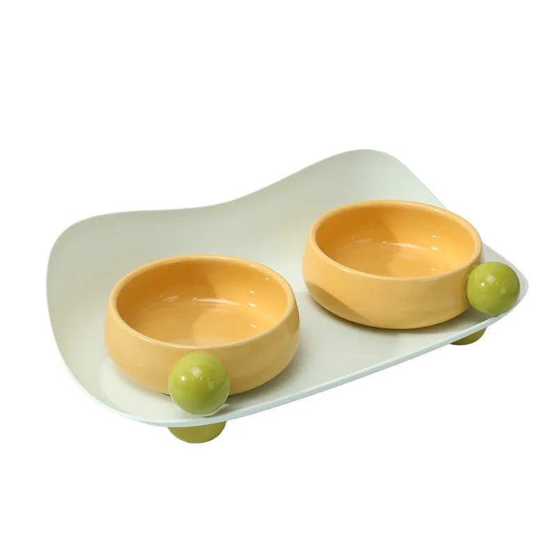 Elevated double ceramic pet bowl set in pink or yellow with non-slip base for cats and small dogs