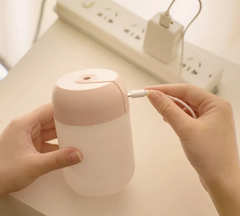 Small white cylindrical USB-powered humidifier on a desk