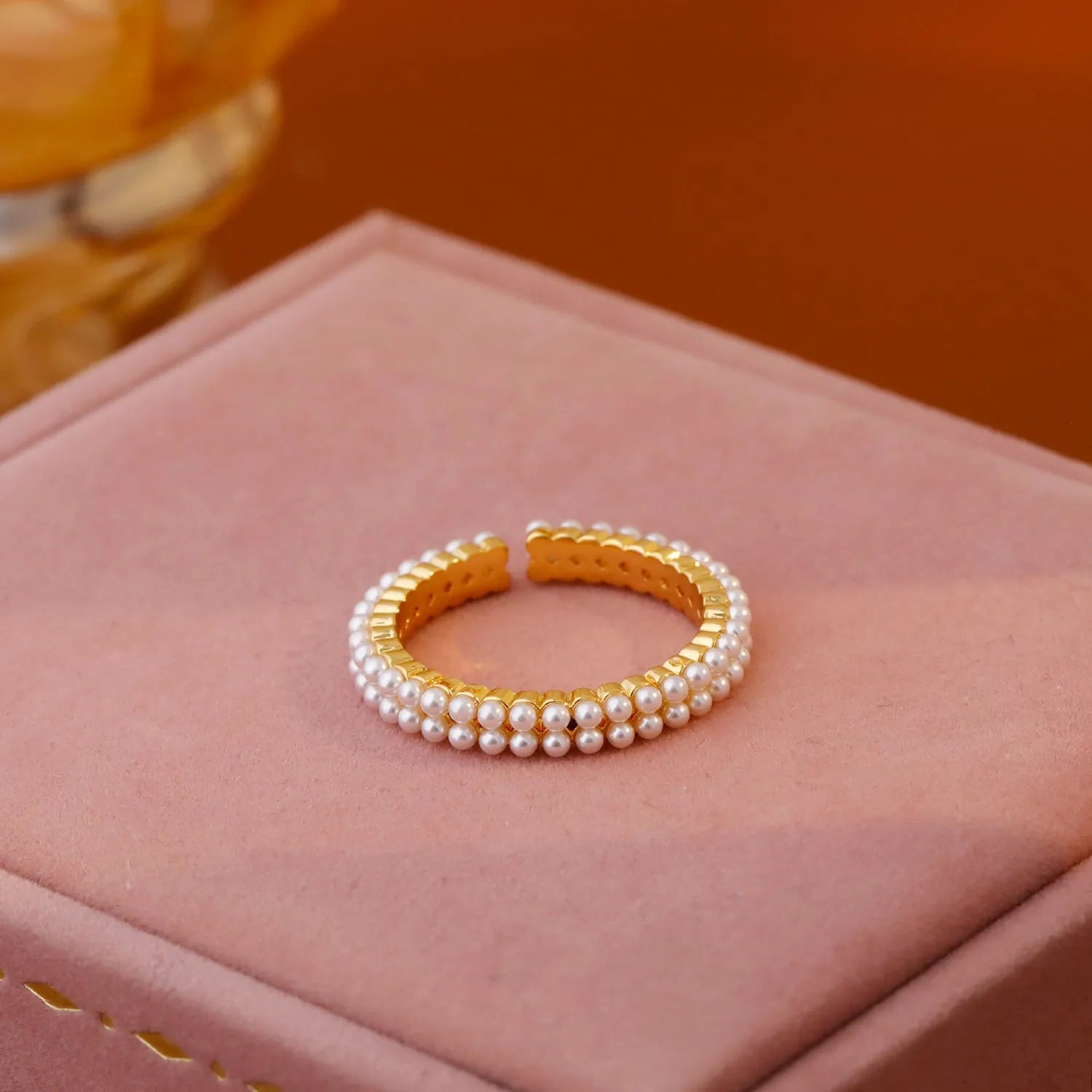 Gold coloured open mouth ring with geometry modelling and round design elements on copper base