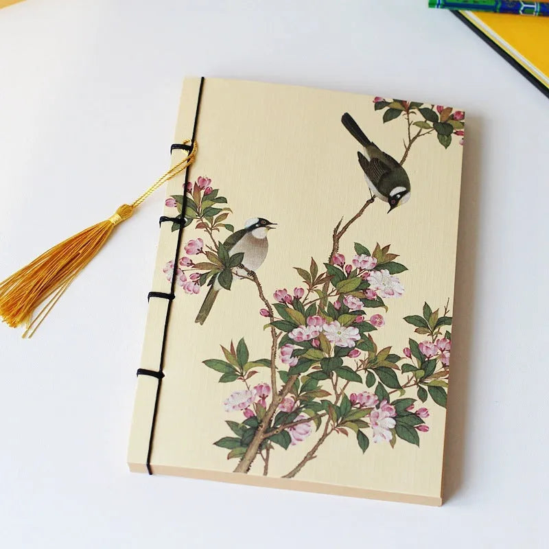 A5 antique wire-bound notebook with glossy embossed cover featuring a retro painting design, shown open.