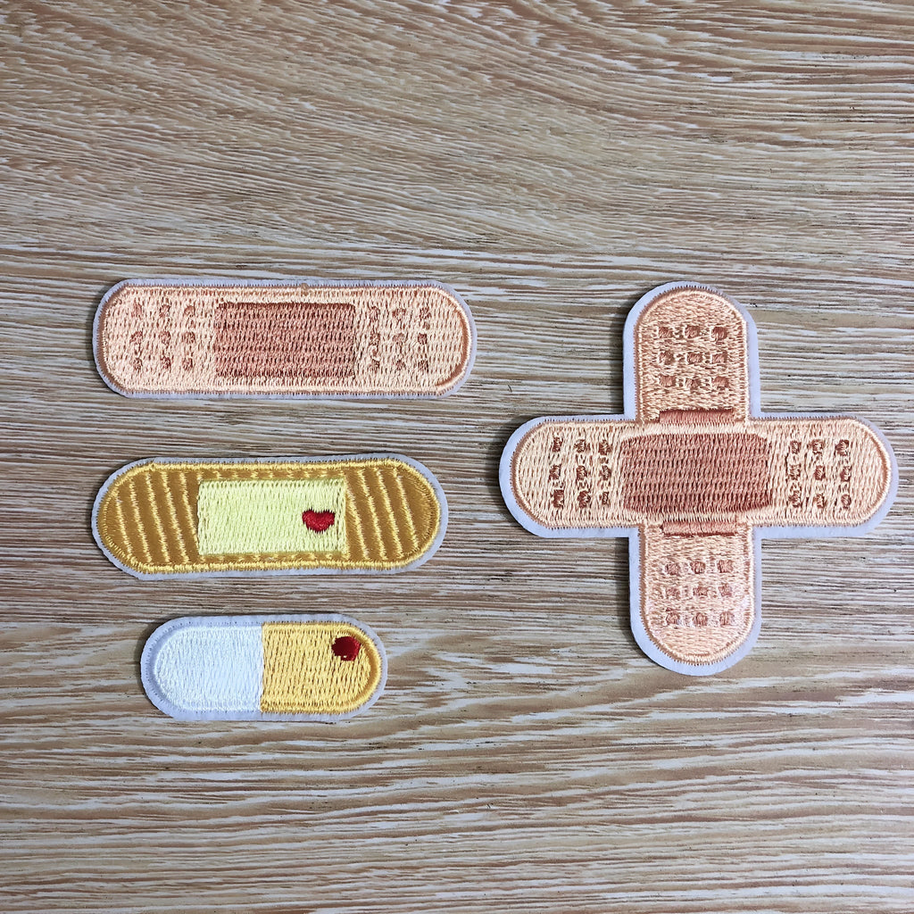 Pack of 10 colourful embroidered iron-on patches for clothing decoration.
