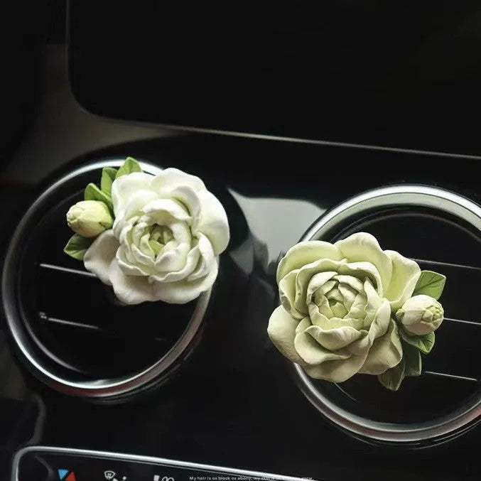 Jasmine scented gypsum solid car perfume clipped to a car air vent in off white or fresh green.
