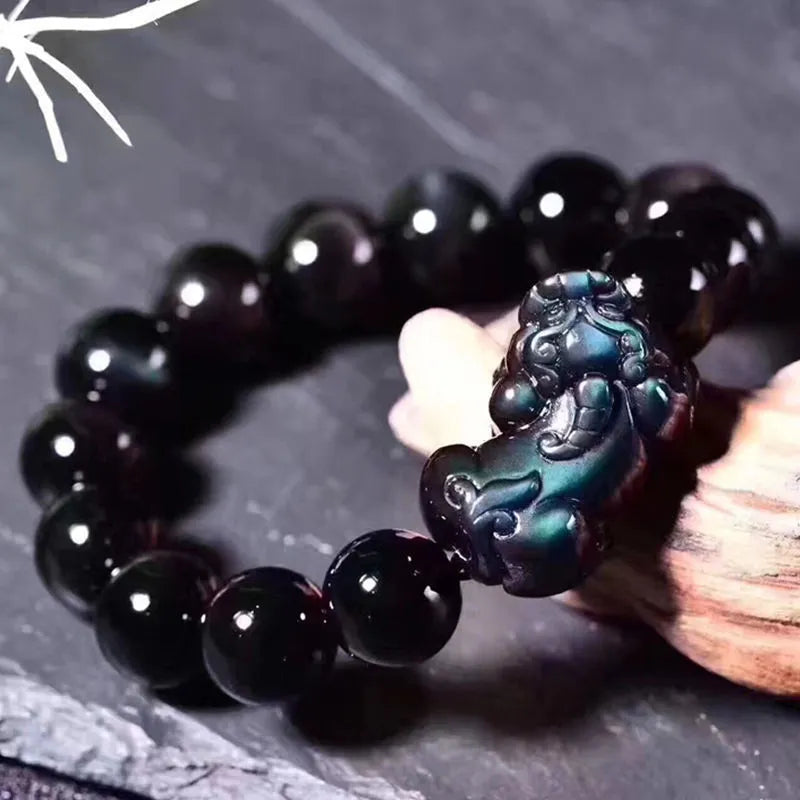 Natural ice colour eye obsidian crystal bracelet on a wrist, showing polished beads.