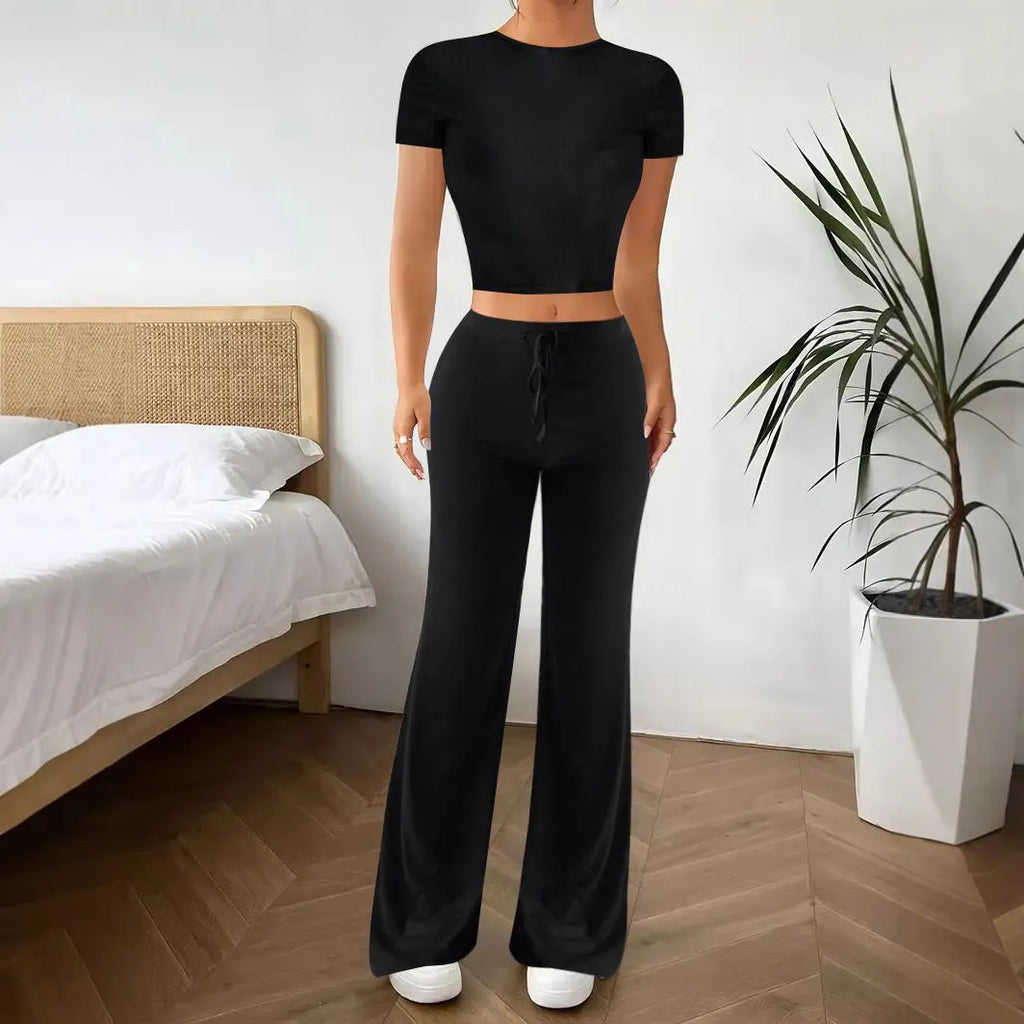 Women's black high waist trousers and regular sleeve t-shirt two-piece set laid flat.
