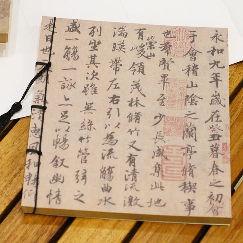 A5 antique wire-bound notebook with glossy embossed cover featuring a retro painting design, shown open.