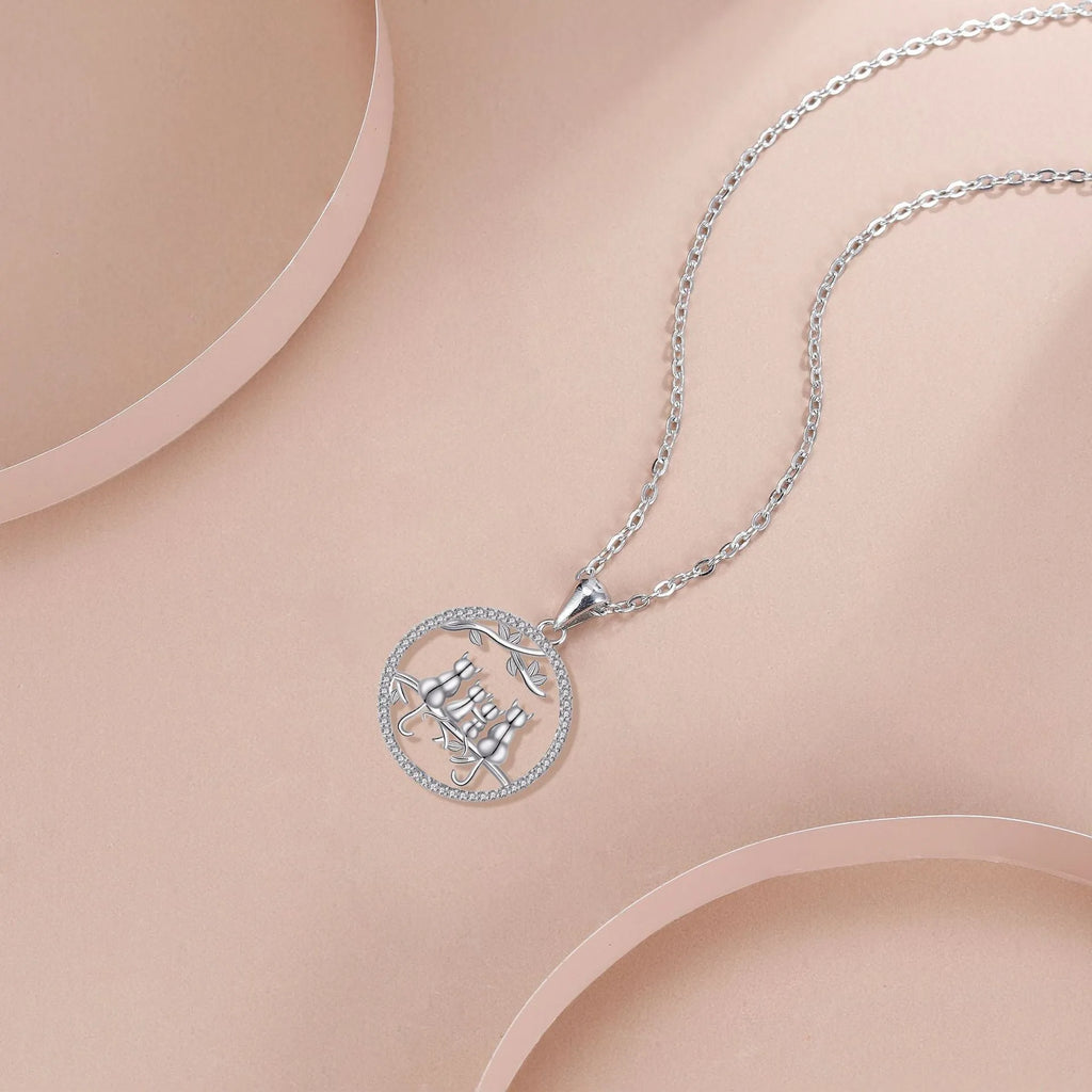 Women's copper necklace with an electroplated pendant showing four kittens on a cross chain.