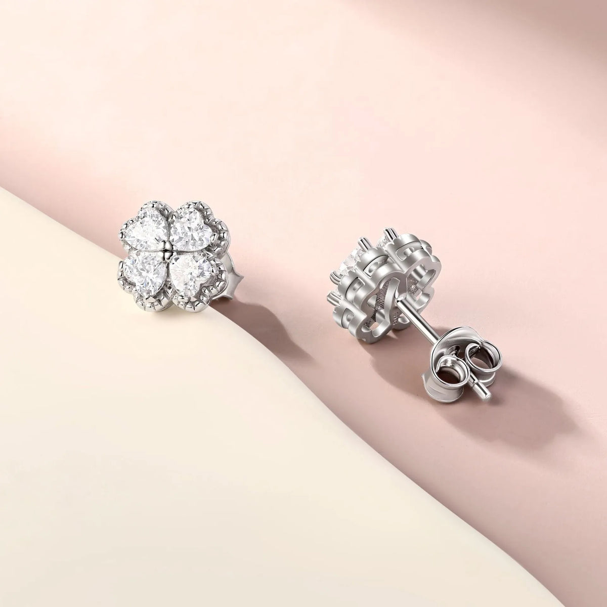Close-up of women's heart-shaped 925 silver earrings with four-leaf clover zircon inlay, white gold colour finish.