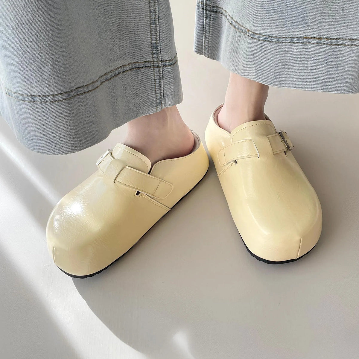 Casual flat buckle sneakers in yellow with round toe, shown on a white background.