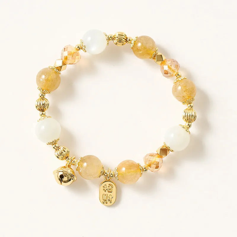 Gold electroplated adjustable bracelet with lucky fortune rutilated quartz crystal beads in a Korean style.