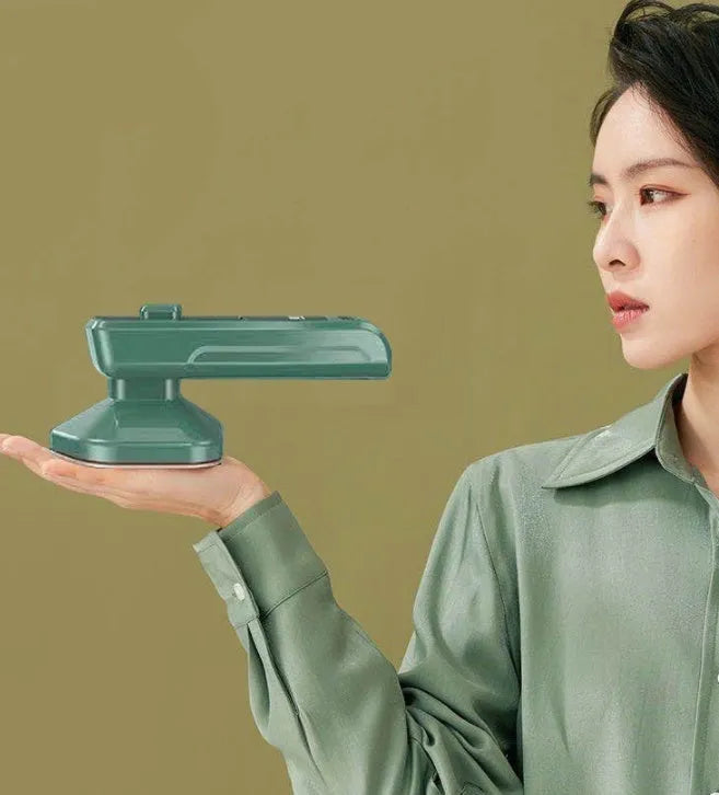 Dark green hand-held steam iron with ceramic panel showing dual temperature buttons and compact design