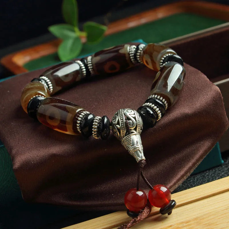 Distressed agate bracelet with traditional Tibetan dzi beads including three-eye and Nine Eyes designs.