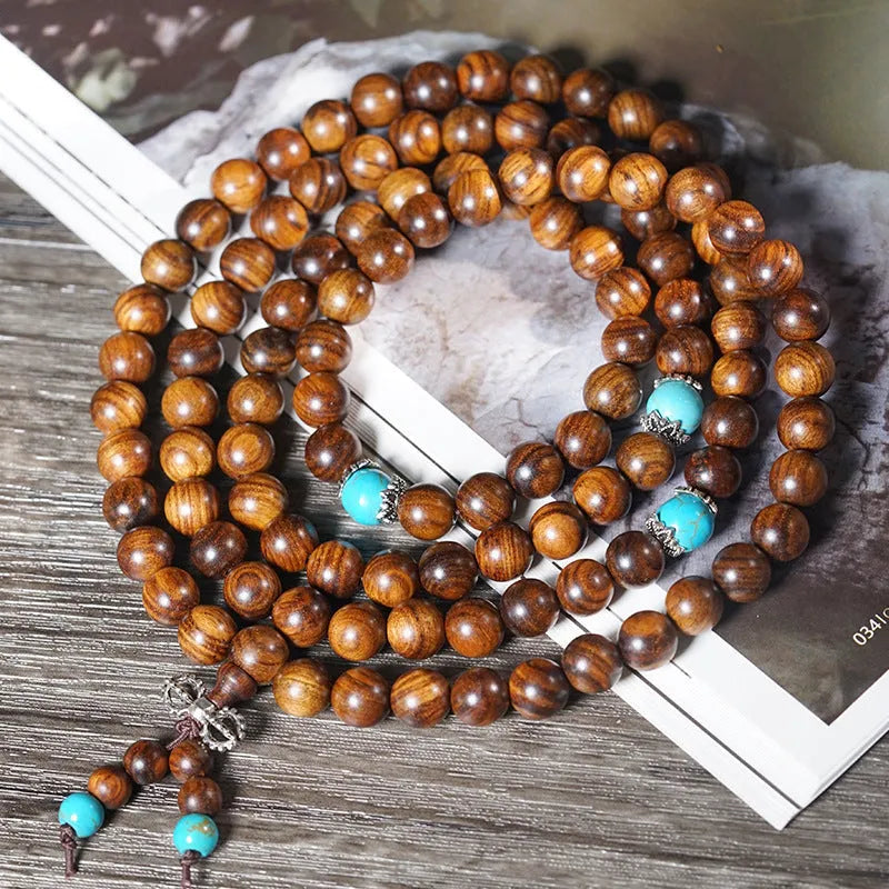 Handmade stone bead bracelet with 108 round geometric beads on a wrist.