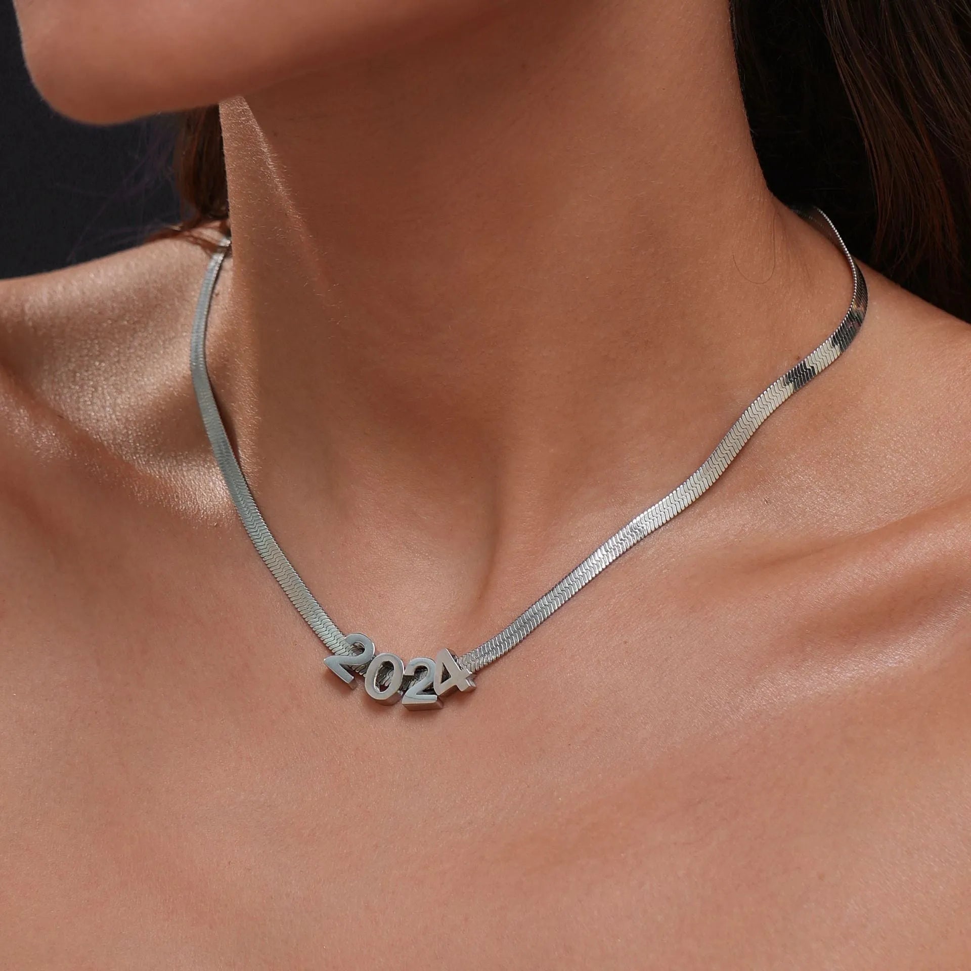 Gold electroplated titanium steel necklace with a letter A charm on a grinding chain.