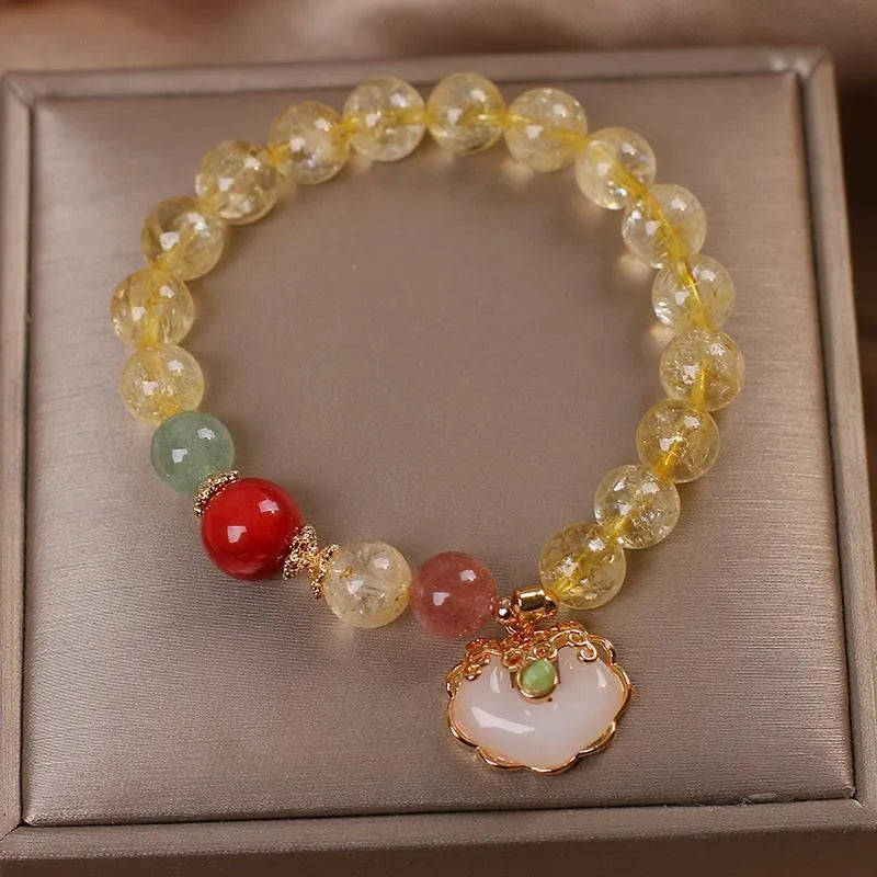 Yellow citrine jade ruyi pendant on an alloy women's bracelet.