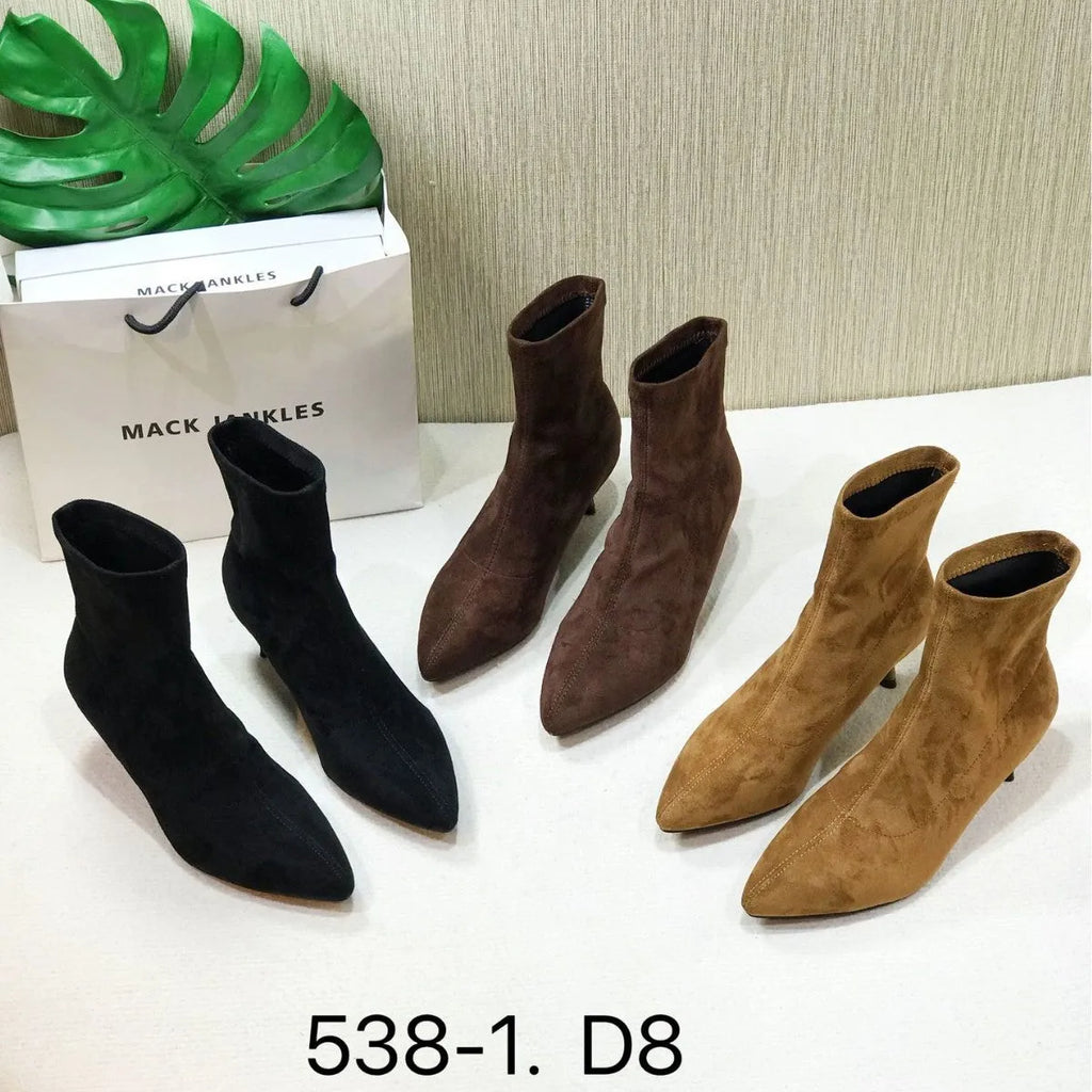 Black pointed toe women's ankle boots with a stiletto heel on a plain background