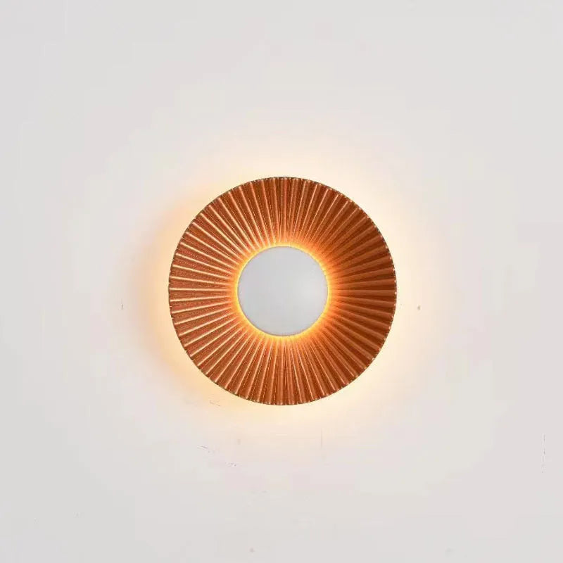 Round aluminium LED wall lamp in outer white and inner gold finish mounted on a wall.
