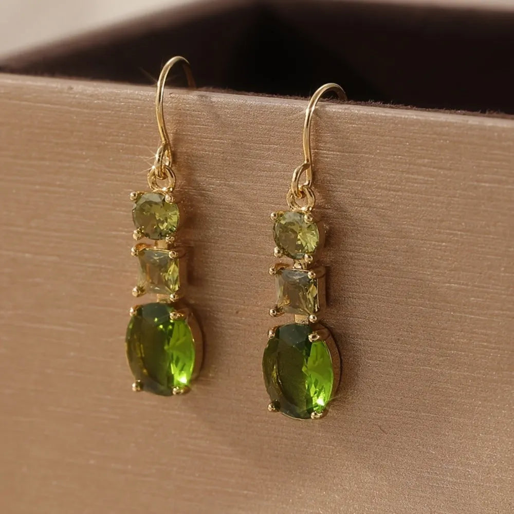 A pair of green geometric quadrilateral copper earrings in a bohemian style for unisex wear.