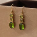 A pair of green geometric quadrilateral copper earrings in a bohemian style for unisex wear.