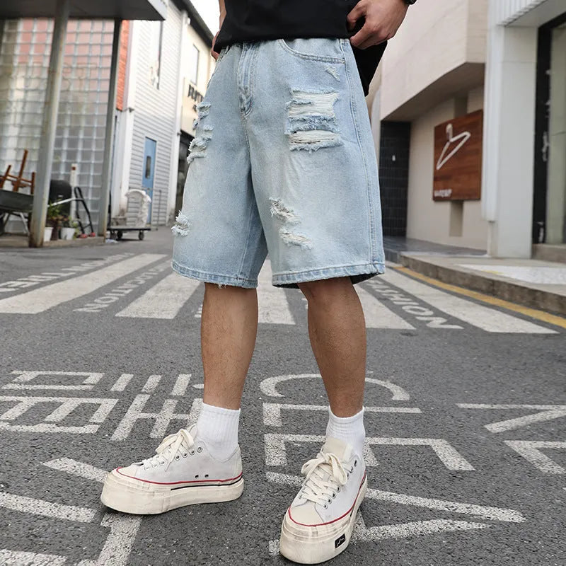 Light blue distressed denim shorts with ripped details, shown in a loose, straight-leg hip-hop style fit.