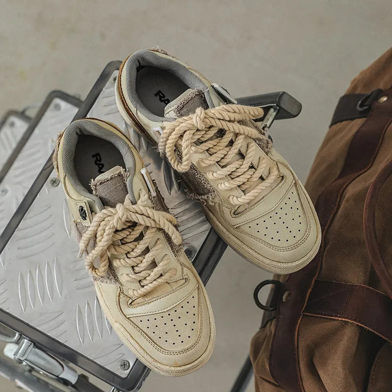 Beige low-top vintage style skate shoes with lace-up front and rubber sole.