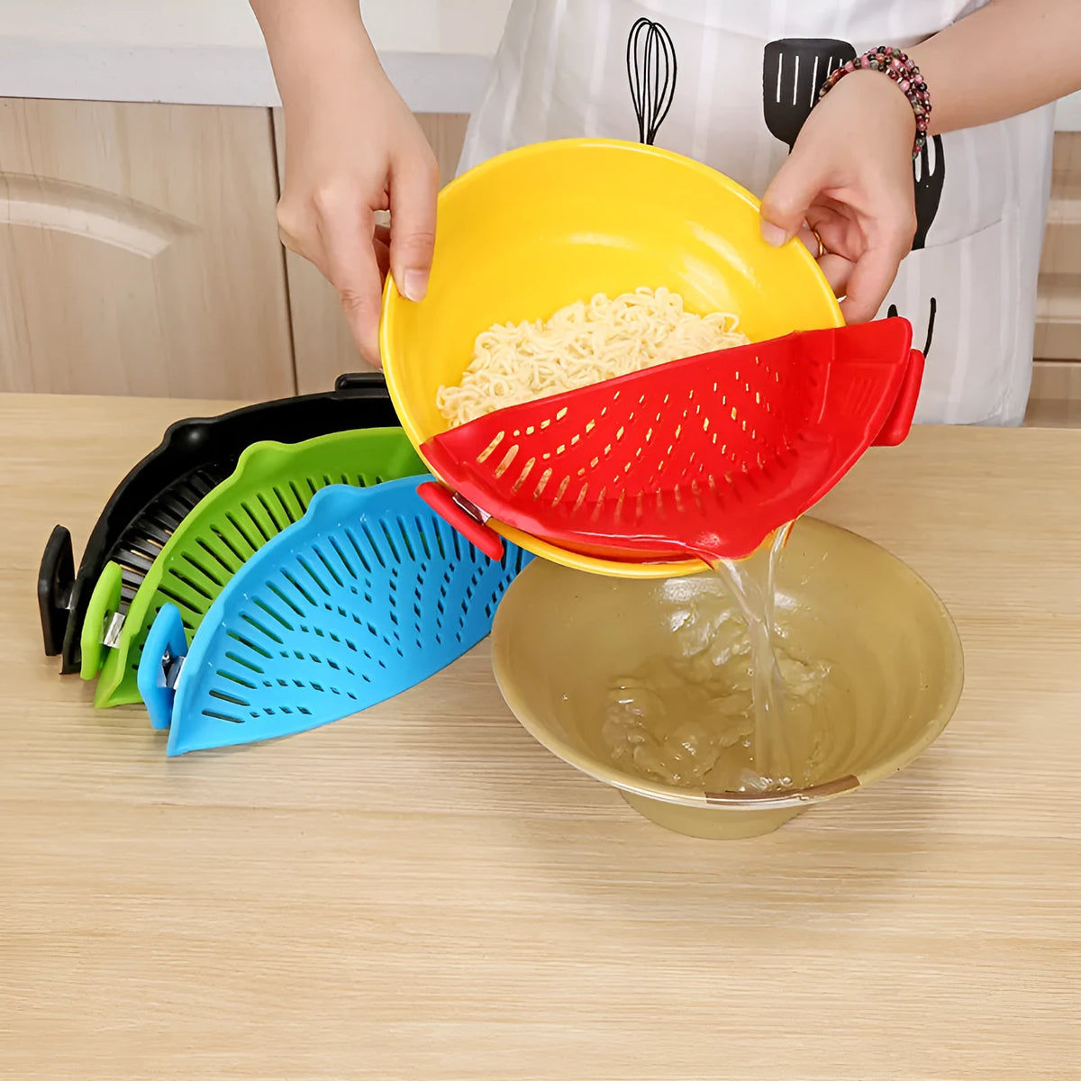 Silicone clip-on funnel strainer attached to kitchen pot for draining liquids