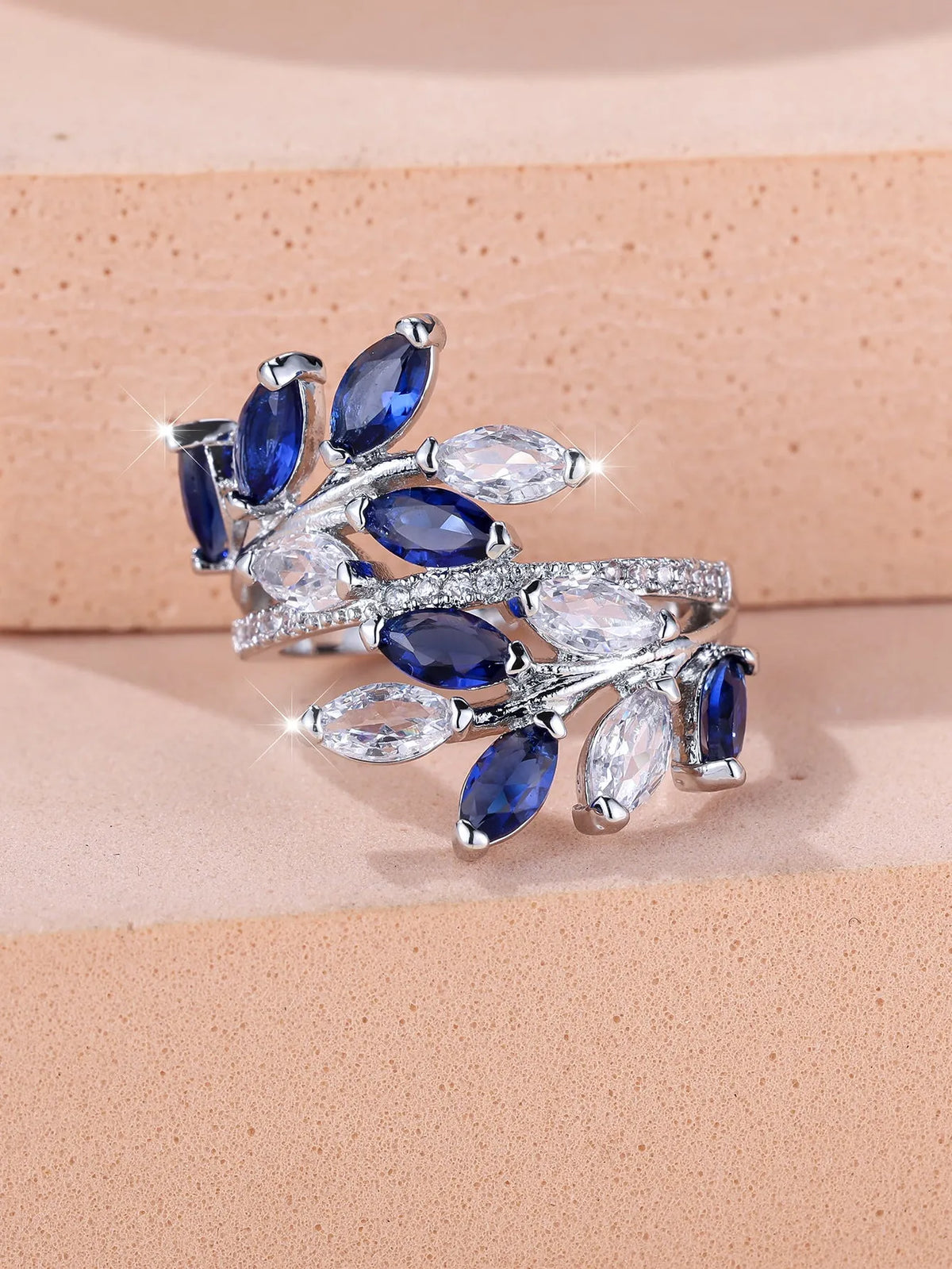 Adjustable horse eye zircon leaf ring in rose gold or platinum plating on a model's hand.