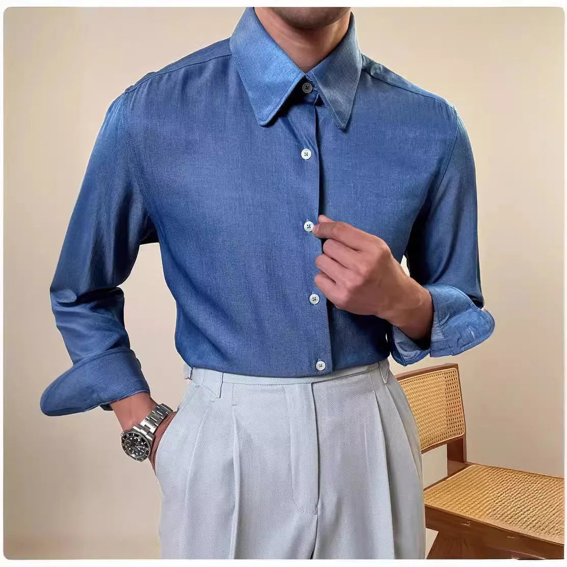 Man wearing a slim fit blue round collar long sleeve shirt made from a rayon and polyester blend.