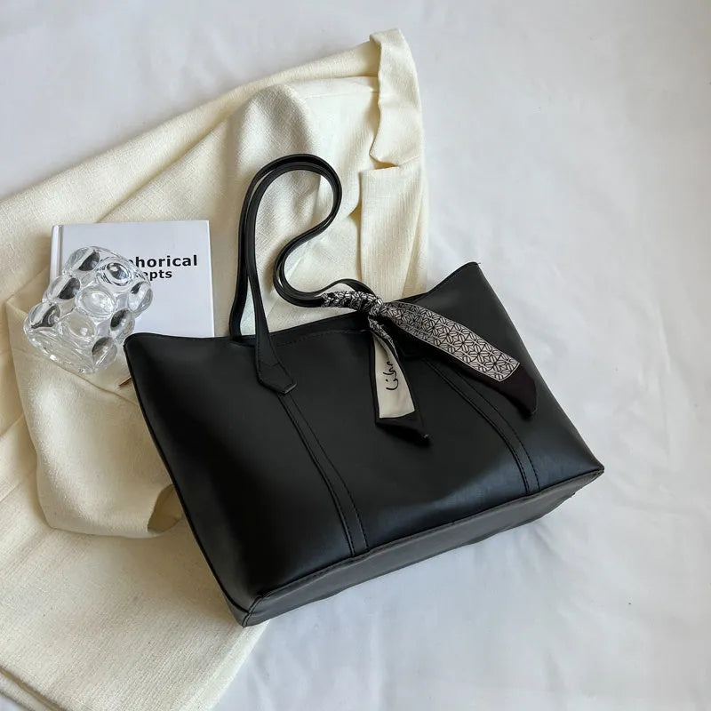 Large soft tote bag in bucket style with crossbody strap and sewing line detailing
