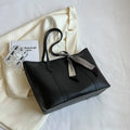 Large soft tote bag in bucket style with crossbody strap and sewing line detailing