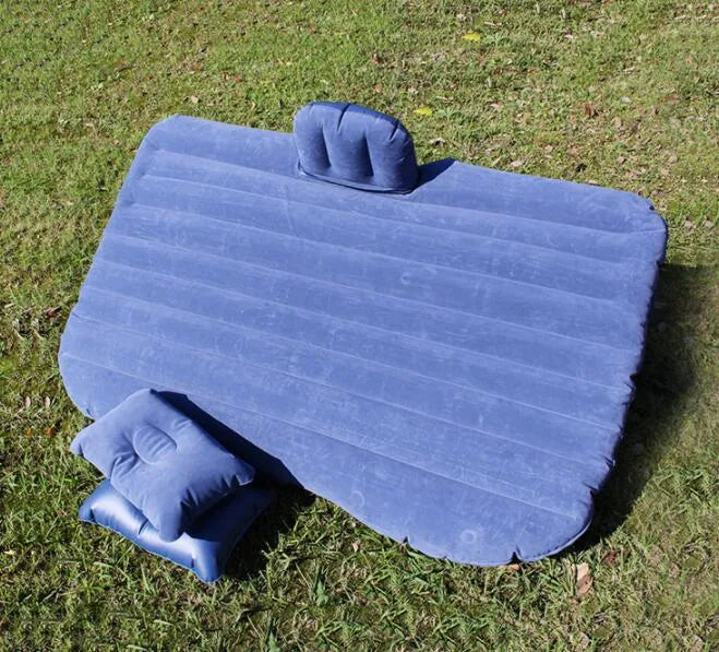 Black inflatable car bed with flocked texture, shown with two pillows inside a car.