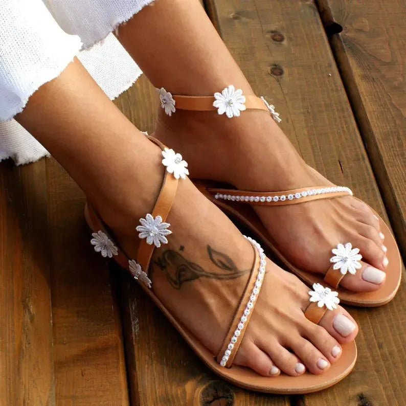 Brown women's casual sandals with flat rubber soles and floral decorations on the upper.