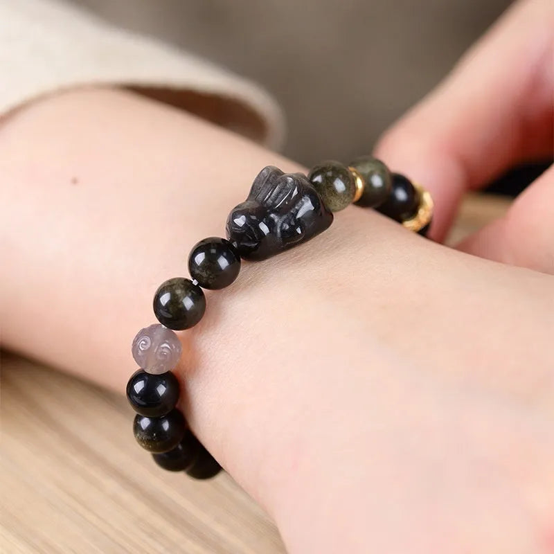 Handmade grey agate and silver lying rabbit charm bracelet on wrist, showing 10mm bead size option.