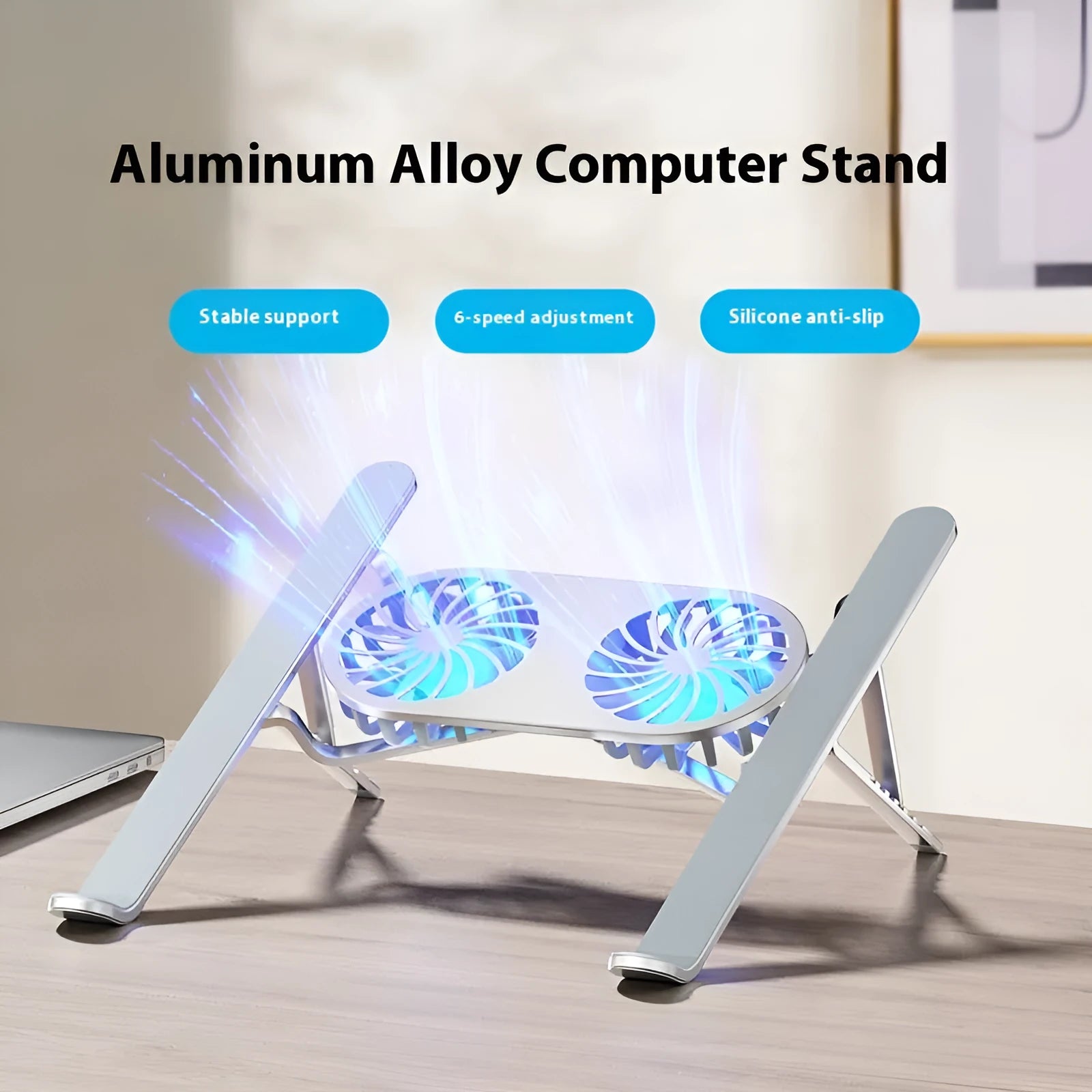 Silver aluminium folding laptop stand with twin cooling fans deployed on a desk.