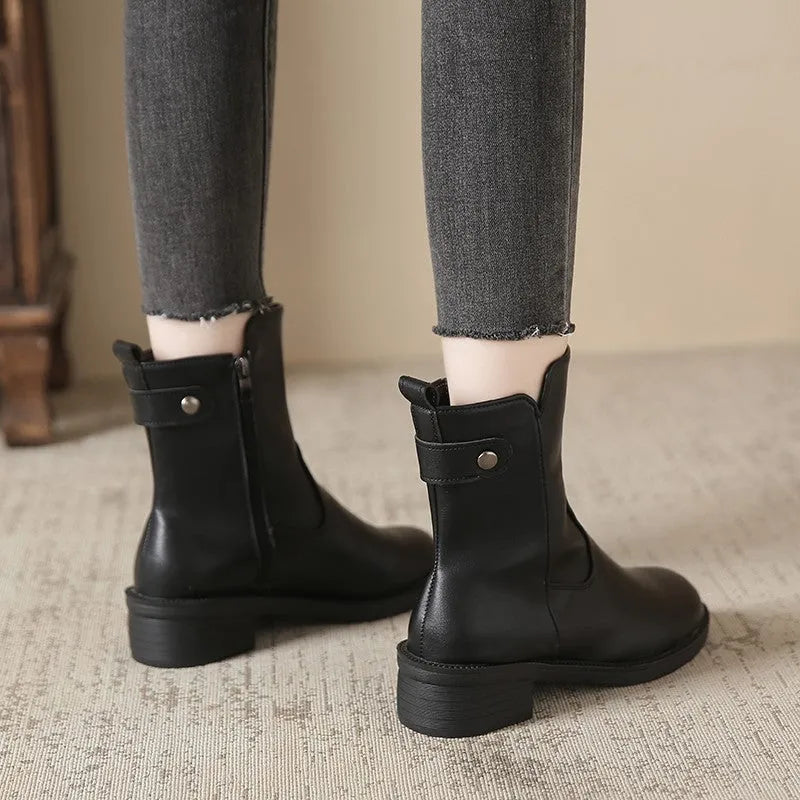 Black women's ankle boots with a side zip and round toe on a low heel.