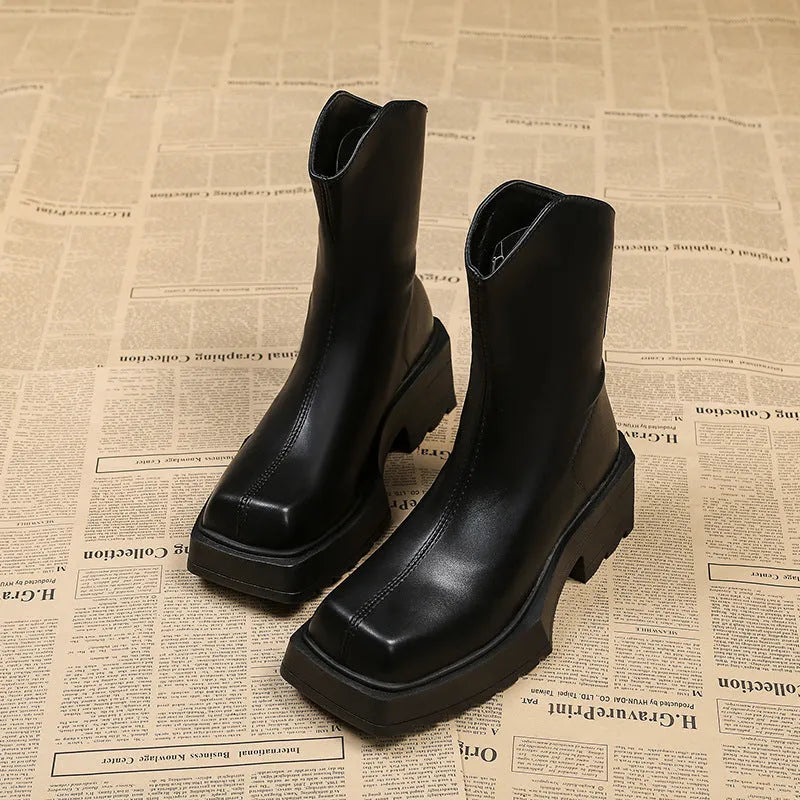 Women's black platform Martin boots with square toe, chunky heel, and back zipper on a plain background