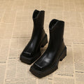 Women's black platform Martin boots with square toe, chunky heel, and back zipper on a plain background